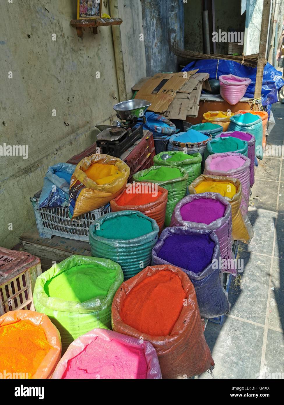 PONDICHERRY, INDE - 18 janvier 2026 : De grands sacs remplis de pigments poudreux aux couleurs vives sont alignés pour la vente le long d'un étal de marché de rue. Banque D'Images