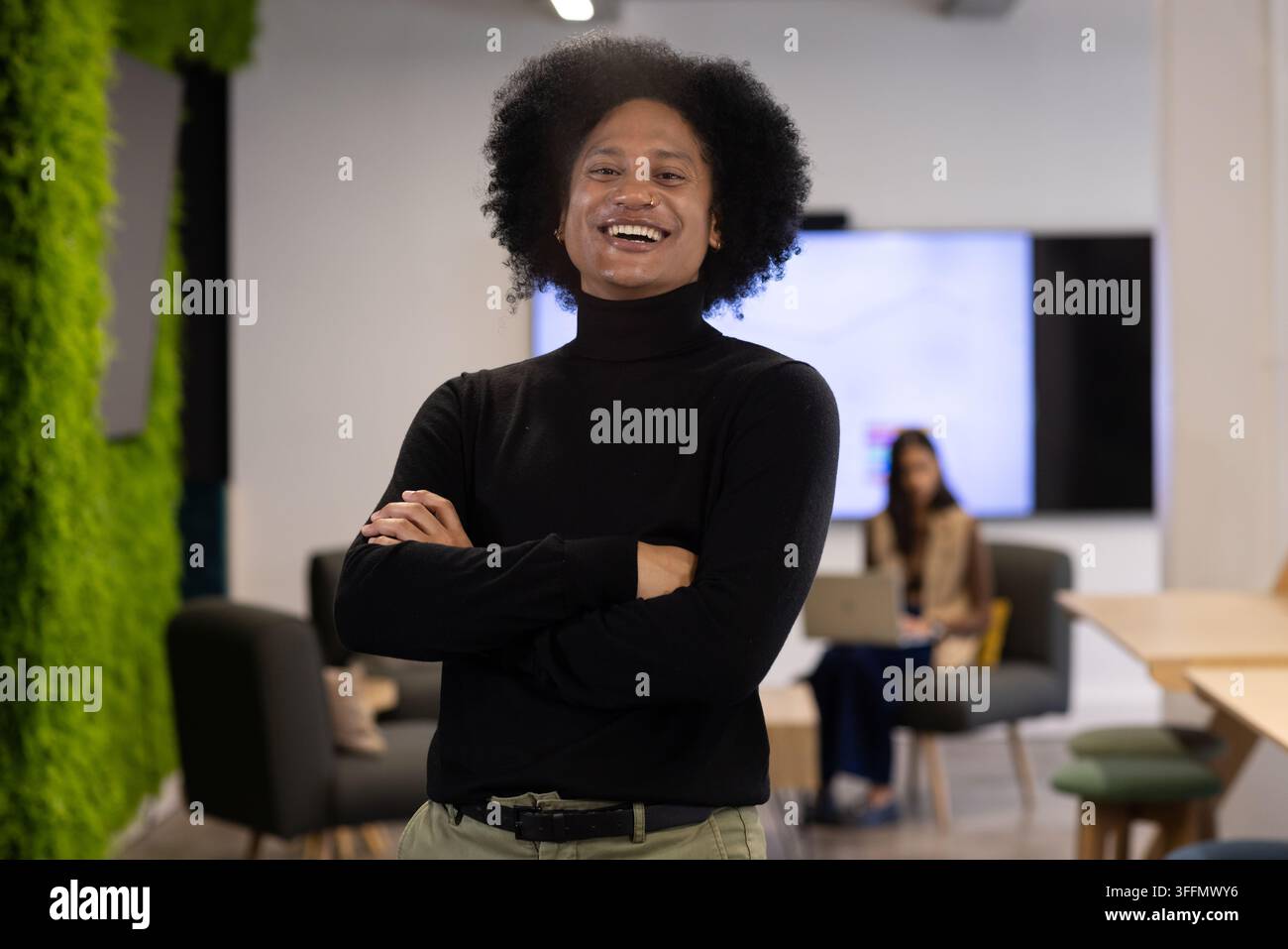 Collègues afro-américains debout travaillant dans le salon de bureau avec un homme en col roulé Banque D'Images