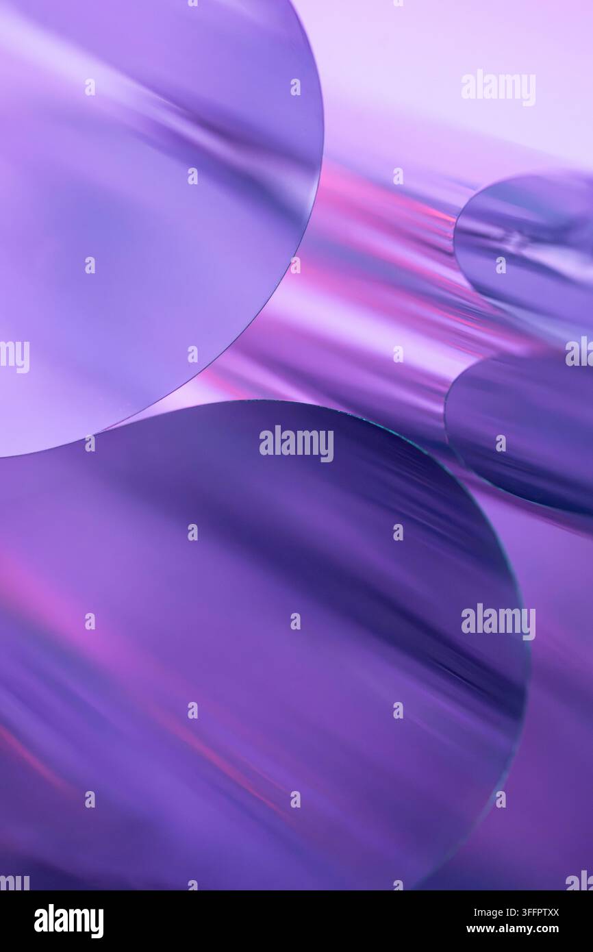 Composition abstraite de cylindres métalliques courbés et de formes circulaires réfléchissantes dans une lumière violette, violette et rose, créant un arrière-plan futuriste élégant Banque D'Images