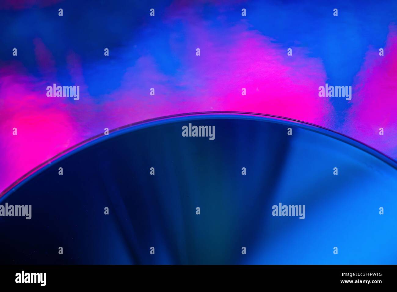 Composition futuriste abstraite mettant en scène un disque circulaire bleu brillant contre une fumée rose et bleue vibrante, créant un arrière-plan néon technique dramatique wi Banque D'Images