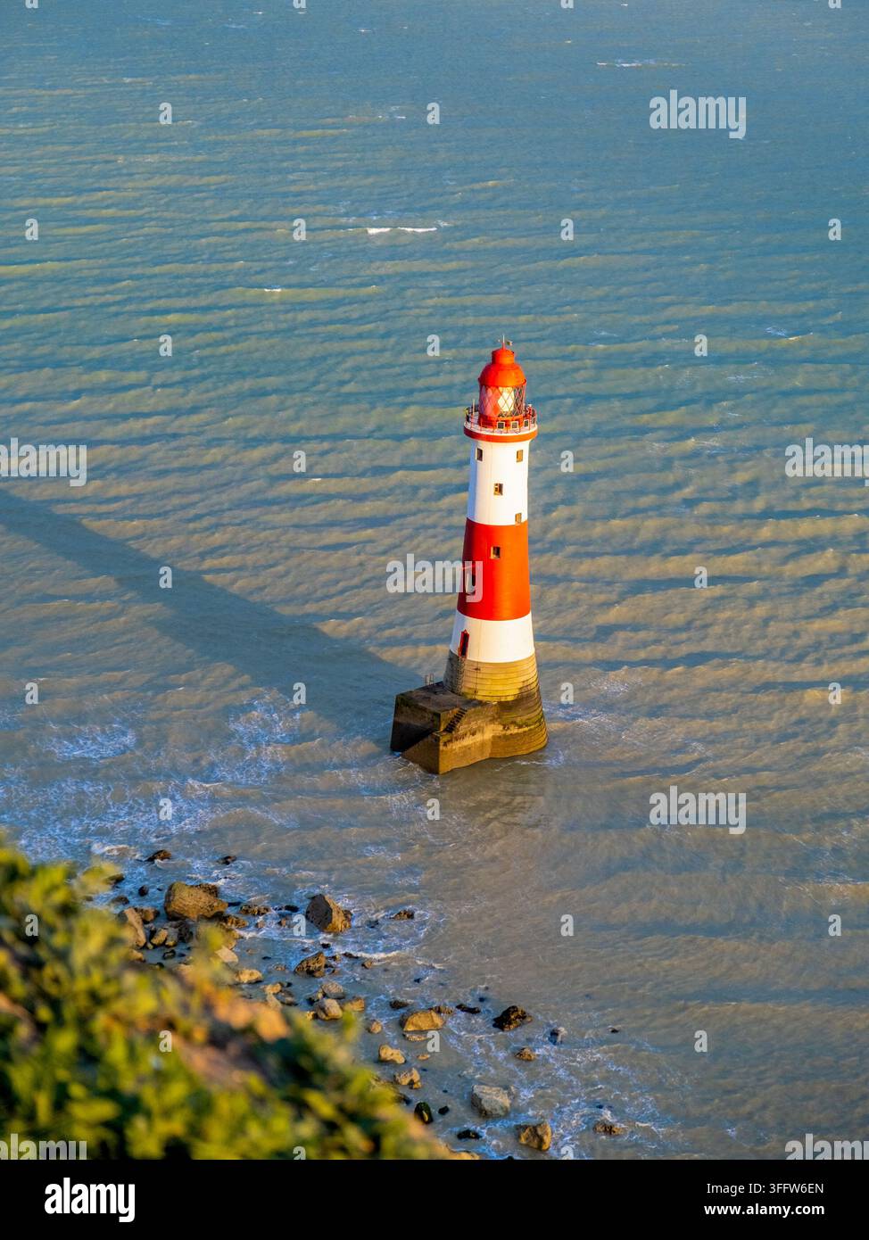 Le phare de Beachy Head se dresse dans la mer au pied des falaises de craie blanches près d'Eastbourne, East Sussex, Angleterre, Royaume-Uni Banque D'Images