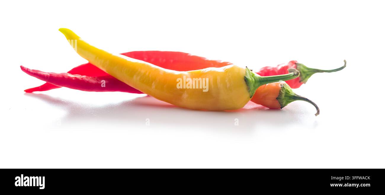 Des piments rouges et jaunes vifs disposés sur un fond blanc immaculé, parfaits pour les plats épicés, la cuisine, les recettes, les ingrédients et le design culinaire. Banque D'Images