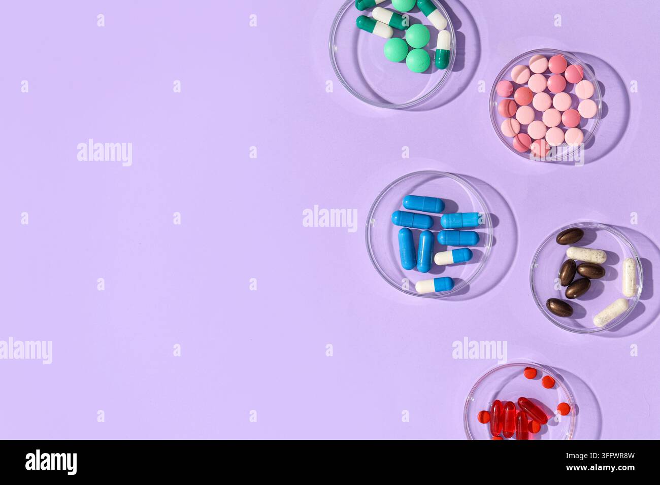 Crise sanitaire et industrie pharmaceutique, diverses pilules et capsules colorées dans des boîtes de Pétri sur un fond violet pour la recherche médicale Banque D'Images