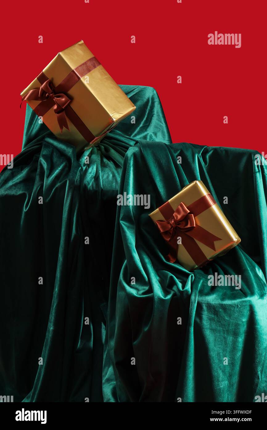Belles boîtes-cadeaux avec tissu de velours vert sur fond rouge Banque D'Images