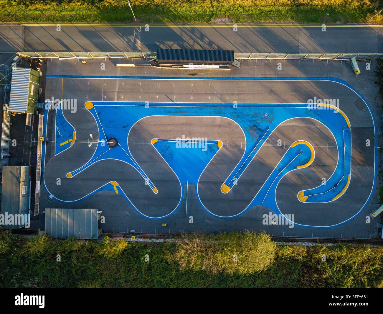 Vue aérienne d'une piste de voiture RC avec de l'asphalte bleu et gris, des bordures jaunes et des courbes complexes à Stafford, Angleterre, Royaume-Uni. Banque D'Images