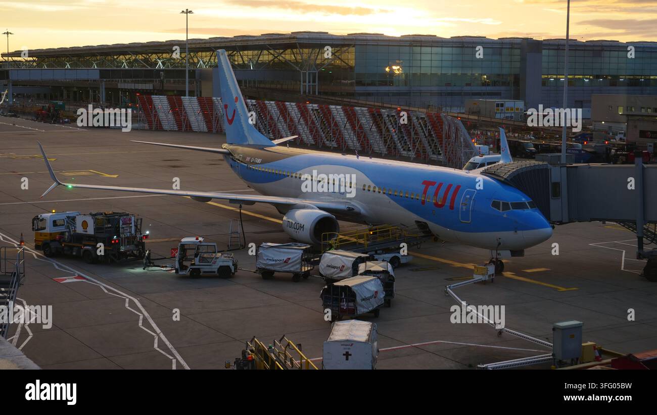 Un avion TUI Boeing 737 attend les passagers à l'aube à l'aéroport de Stansted. Banque D'Images