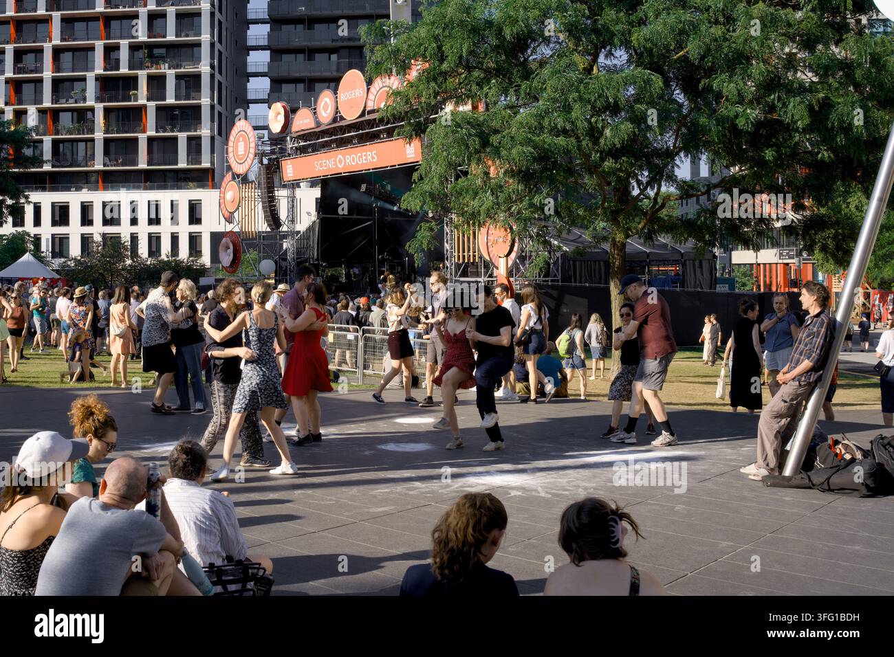 Des gens se rassemblent près d'une scène extérieure pendant le Festival international de jazz de Montréal à Montréal, Québec, Canada, le 5 juillet 2026. Banque D'Images