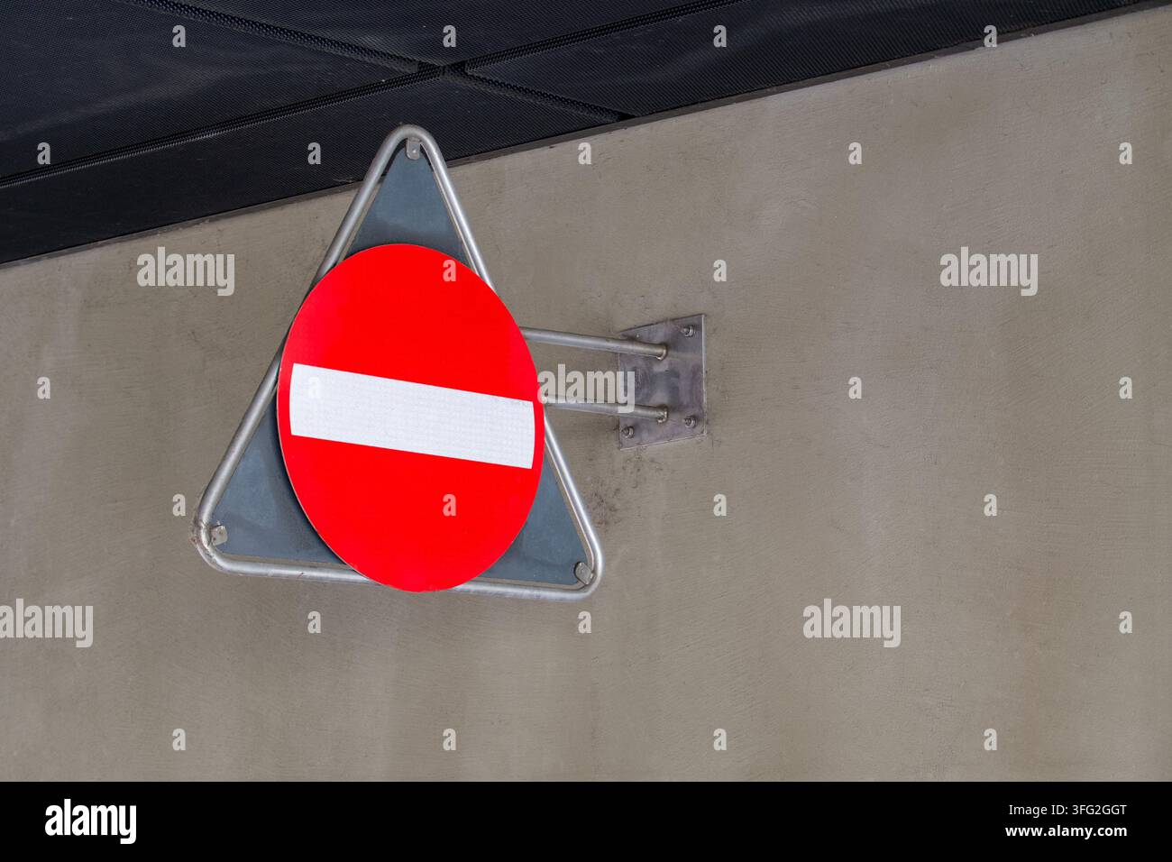 Panneau routier rouge et blanc d'interdiction d'entrée monté sur un mur de béton gris. Concept pour restriction, contrôle de sécurité, règles et réglementations, accès Banque D'Images