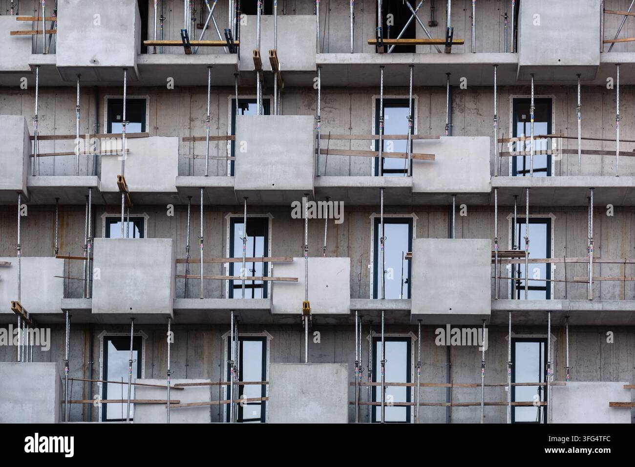 architecture moderne bâtiment résidentiel en construction façade avec béton brut balcons géométriques supports d'échafaudage en acier rampe de sécurité en bois Banque D'Images