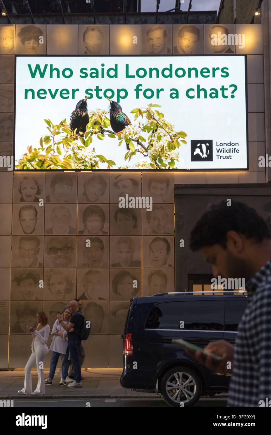 Discussions de groupe sous l'annonce de la London Wildlife Trust "Wild Londoners" la nuit. avec la légende "Qui a dit que les Londoniens ne s'arrêtent jamais pour discuter ?" Banque D'Images