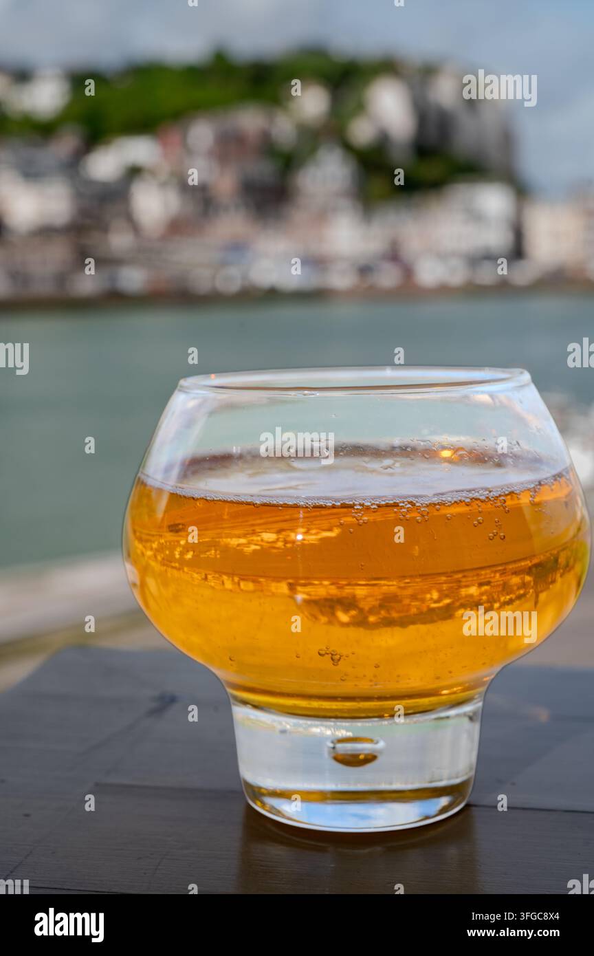 Cidre de pomme de Normandie versé avec vue sur le Tréport avec de superbes falaises de craie dorées, boisson pétillante aux pommes, goût rafraîchissant. Sur fond pictu Banque D'Images