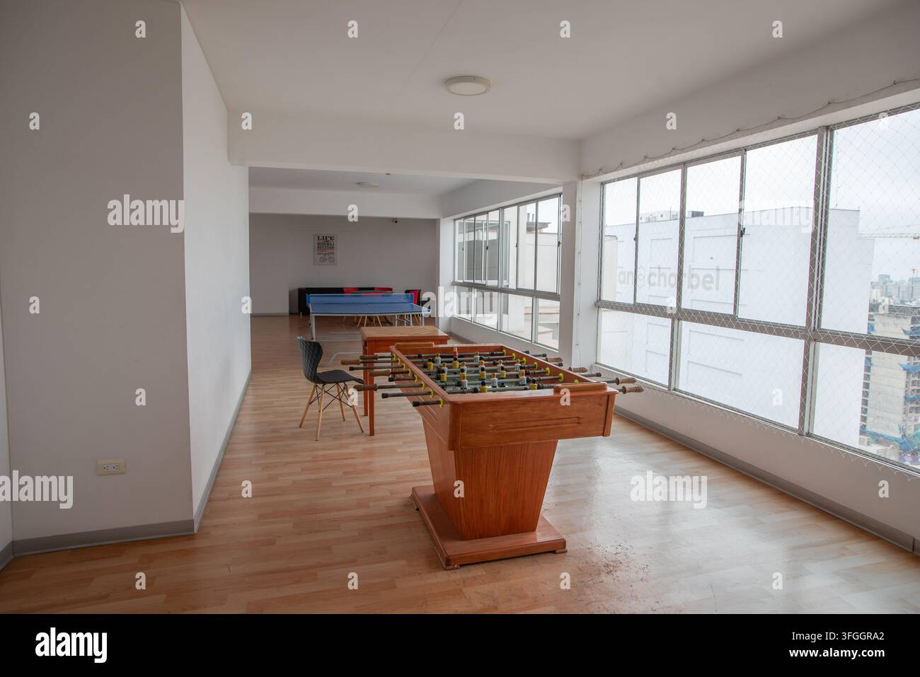 Rec Room Entertainment : Une pièce spacieuse conçue pour les loisirs, avec une table de baby-foot au premier plan et une table de billard en arrière-plan Banque D'Images
