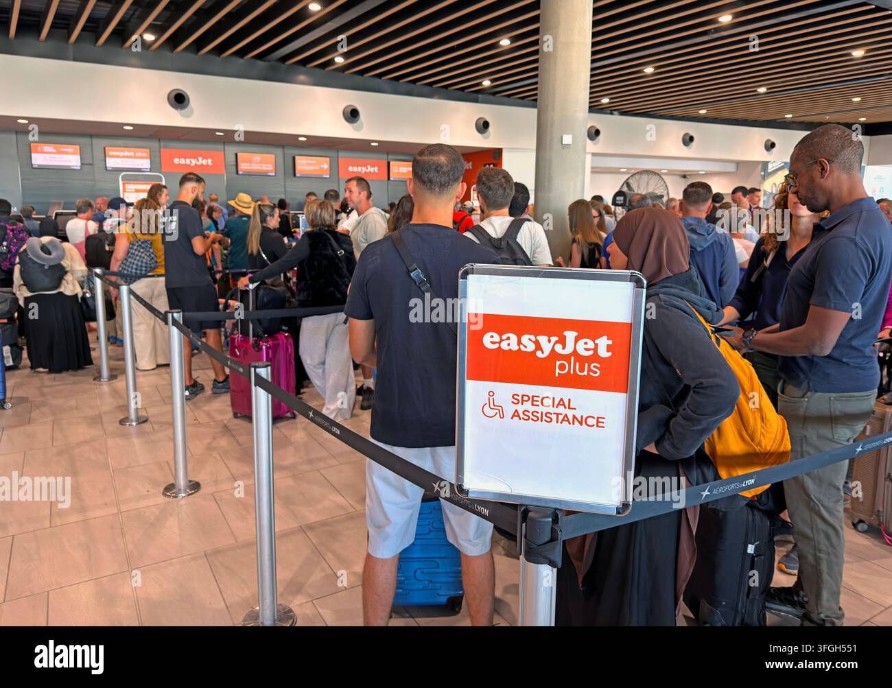 Les passagers font la queue pour le dépôt des bagages et l'enregistrement easyJet à l'aéroport de Lyon, les voies easyJet Plus et assistance spéciale étant visibles. Banque D'Images