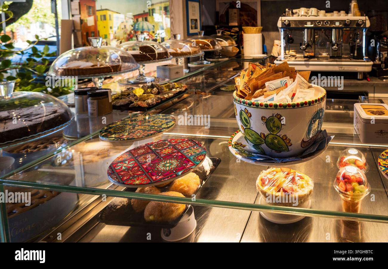 Capo d'Orlando, ME - IT - 4 sep 2026 : Une vue intérieure d'un comptoir de café présentant une vitrine remplie de pâtisseries, des gâteaux sous dôme en verre Banque D'Images