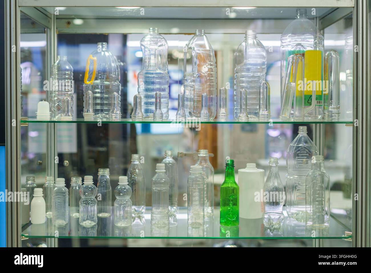 Une vitrine en verre présentant une variété de bouteilles en plastique transparentes, de préformes PET et d'échantillons d'emballages pour l'industrie des boissons et de la fabrication Banque D'Images