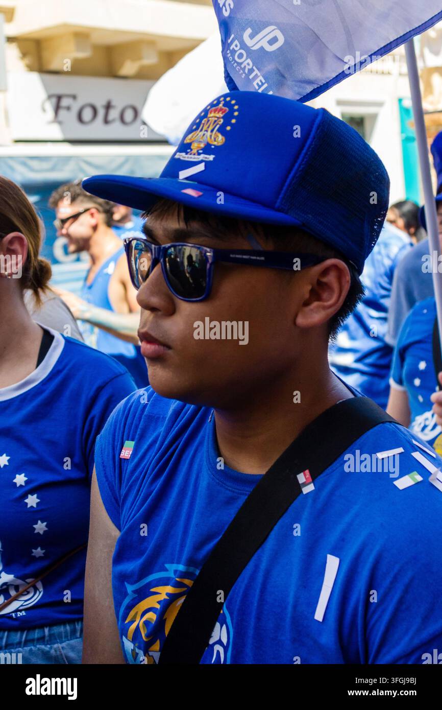 Zabbar, Malte – 12 septembre 2026, jeune fan de sport portant une casquette bleue et des lunettes de soleil lors d’un défilé ou d’un rassemblement d’équipe en plein air Banque D'Images