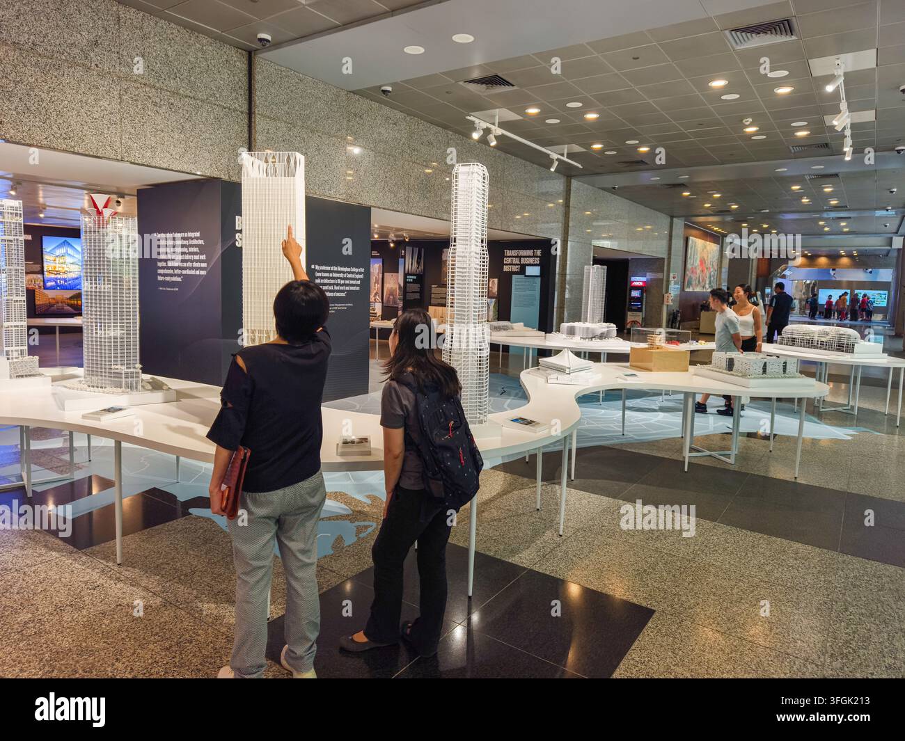 Visiteurs contemplant des maquettes et des expositions architecturales lors de l'exposition «70 ans de RSP : Où le design rencontre l'humanité», organisée au Centre URA à Singapour. Banque D'Images
