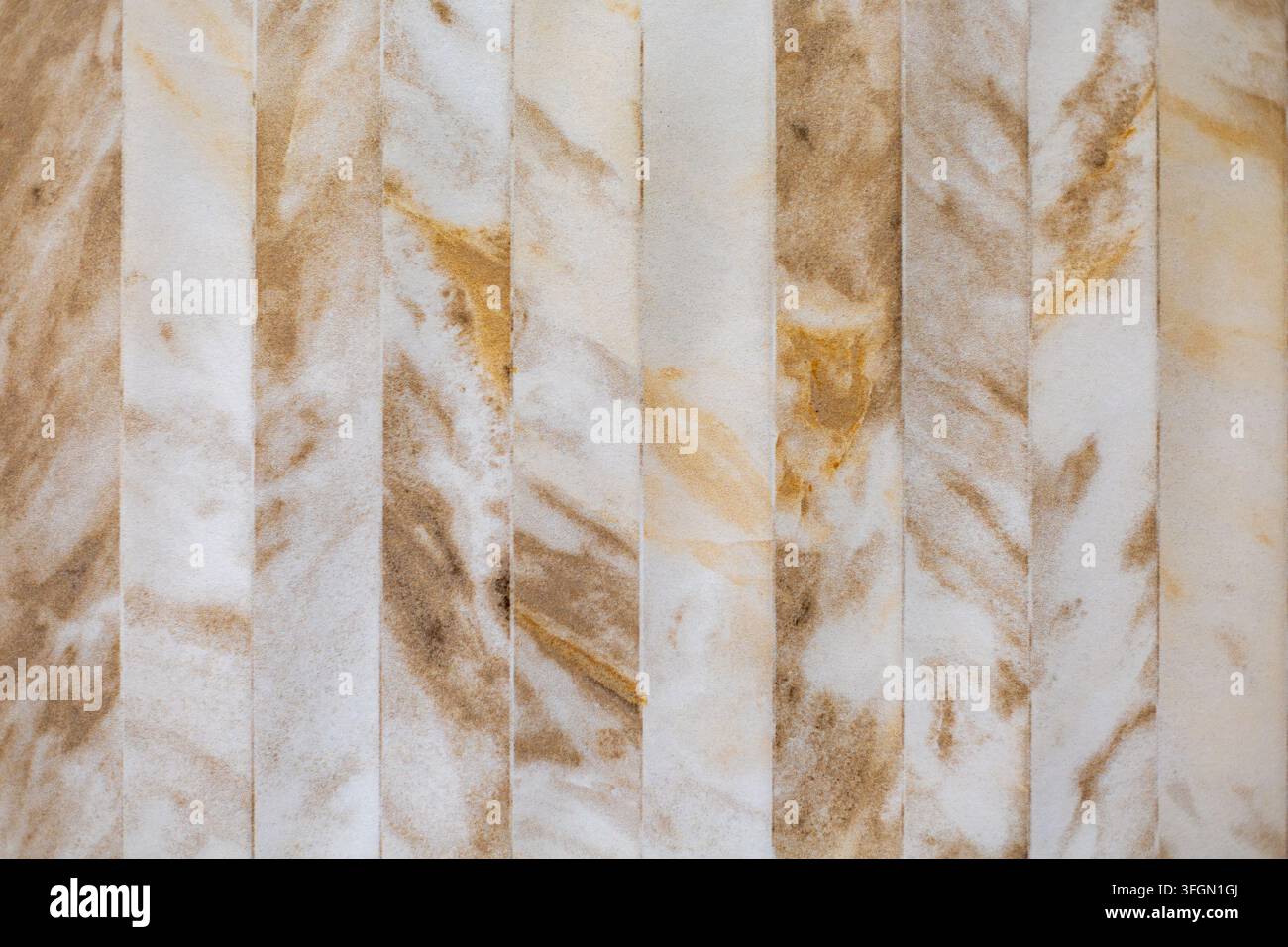 Carreaux muraux effet marbre beige avec veines naturelles. Carreaux effet marbre beige et brun disposés en bandes verticales avec des veines naturelles douces et un Banque D'Images