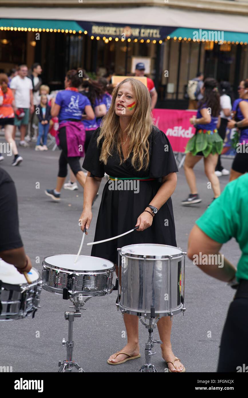 Coureuses en tenues festives assorties célébrant à l'arrivée de l'événement de course féminine La Parisienne sur une rue de Paris en France. Banque D'Images