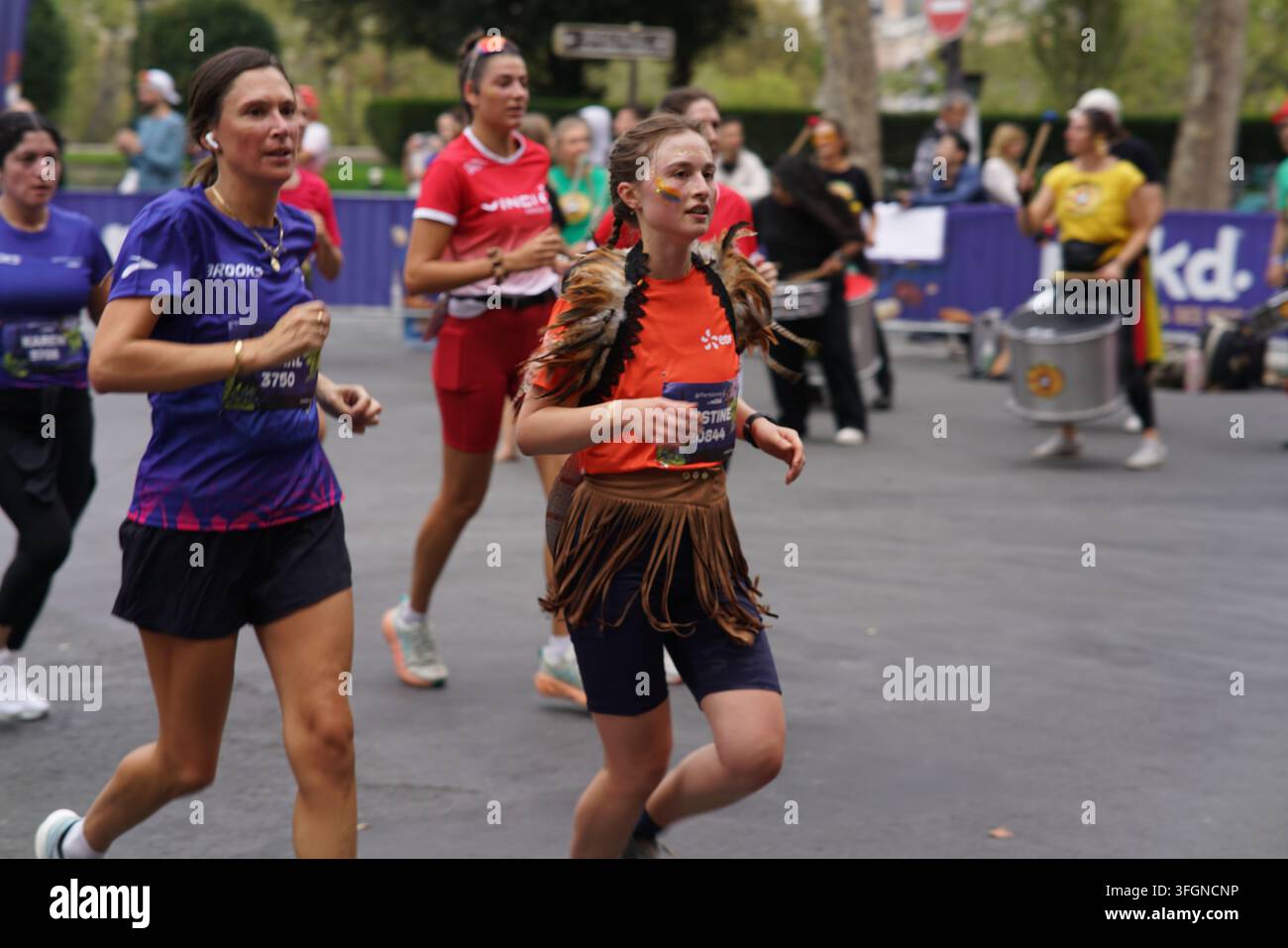 Coureuses en tenues festives assorties célébrant à l'arrivée de l'événement de course féminine La Parisienne sur une rue de Paris en France. Banque D'Images