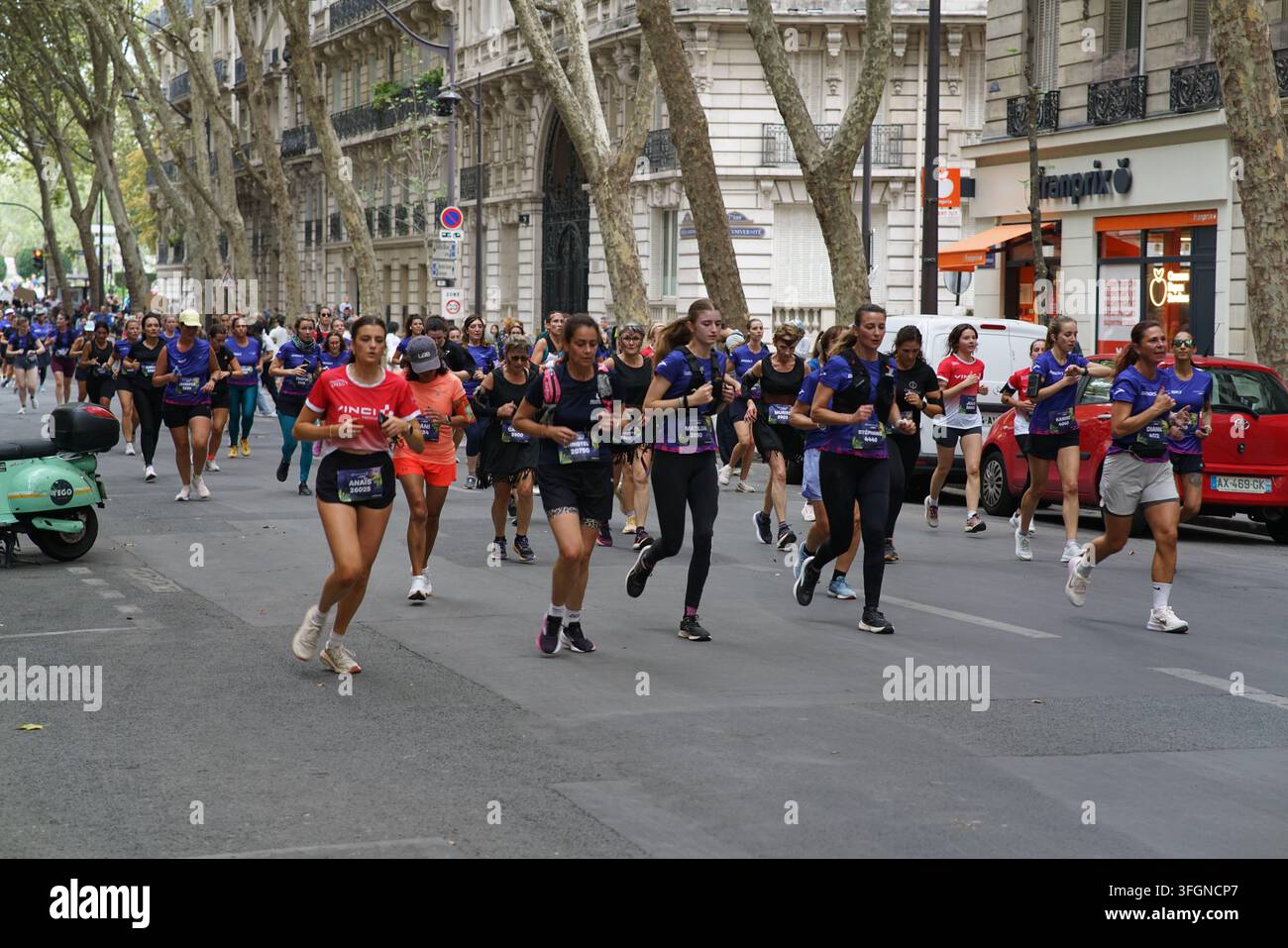Coureuses en tenues festives assorties célébrant à l'arrivée de l'événement de course féminine La Parisienne sur une rue de Paris en France. Banque D'Images