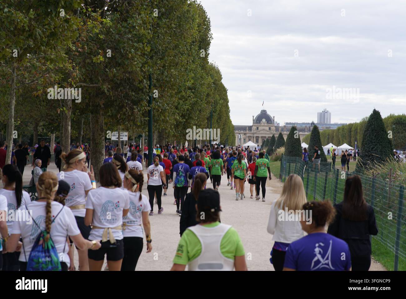 Coureuses en tenues festives assorties célébrant à l'arrivée de l'événement de course féminine La Parisienne sur une rue de Paris en France. Banque D'Images