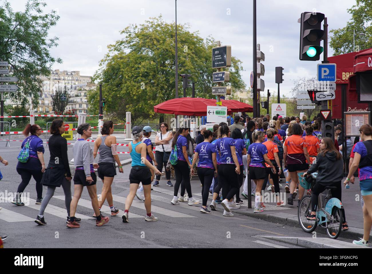 Coureuses en tenues festives assorties célébrant à l'arrivée de l'événement de course féminine La Parisienne sur une rue de Paris en France. Banque D'Images