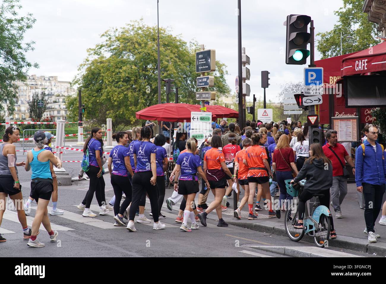 Coureuses en tenues festives assorties célébrant à l'arrivée de l'événement de course féminine La Parisienne sur une rue de Paris en France. Banque D'Images