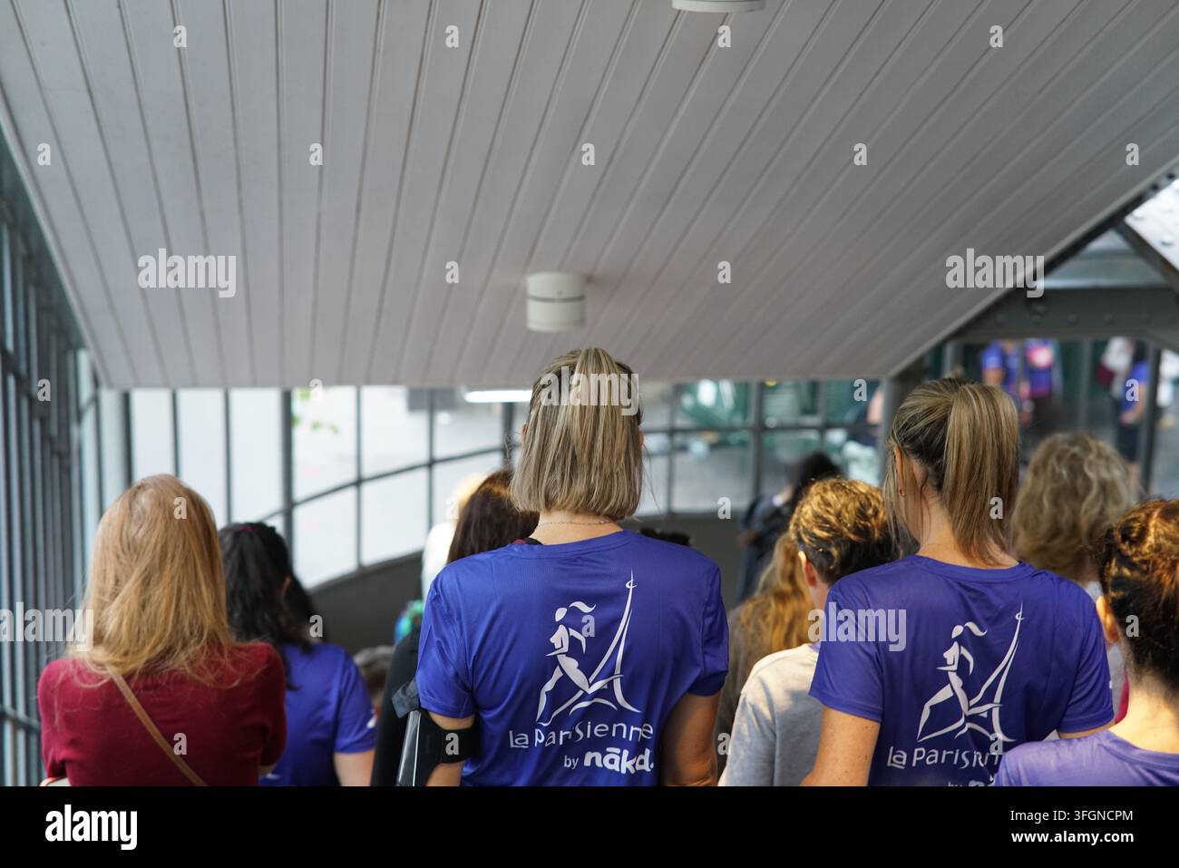 Coureuses en tenues festives assorties célébrant à l'arrivée de l'événement de course féminine La Parisienne sur une rue de Paris en France. Banque D'Images