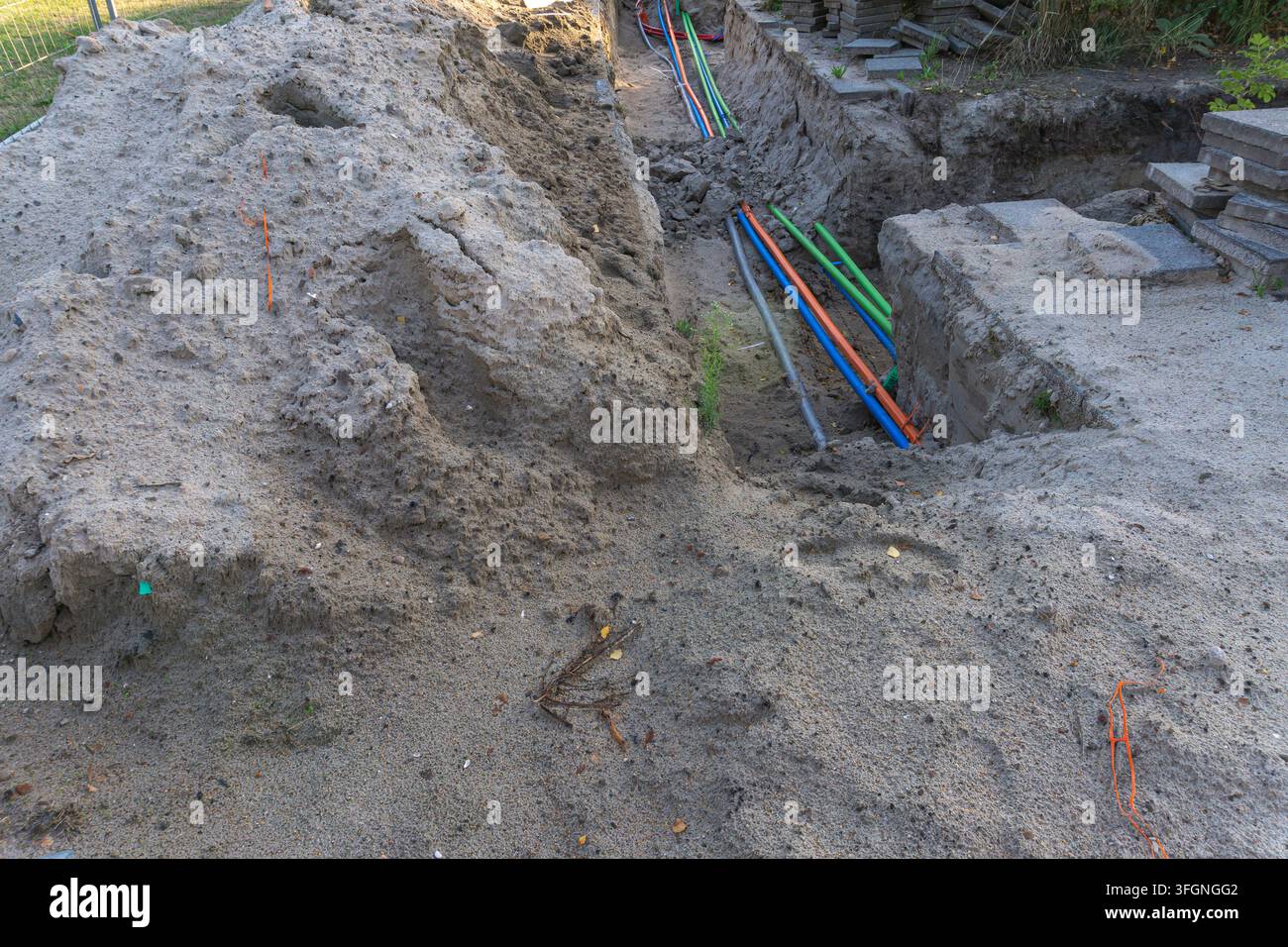 Pose de câble dans une tranchée ouverte le long d'une rue pendant des travaux routiers Banque D'Images