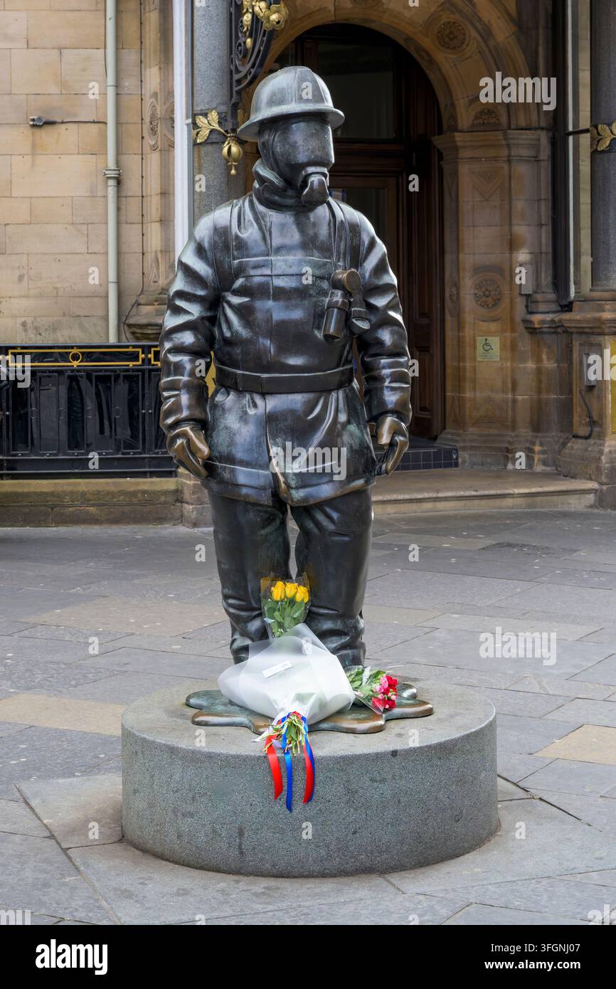 Fleurs déposées sur la sculpture Citizen Firefighter au 25e anniversaire des attentats du 11 septembre, Gordon Street, Glasgow, Écosse, Royaume-Uni Banque D'Images