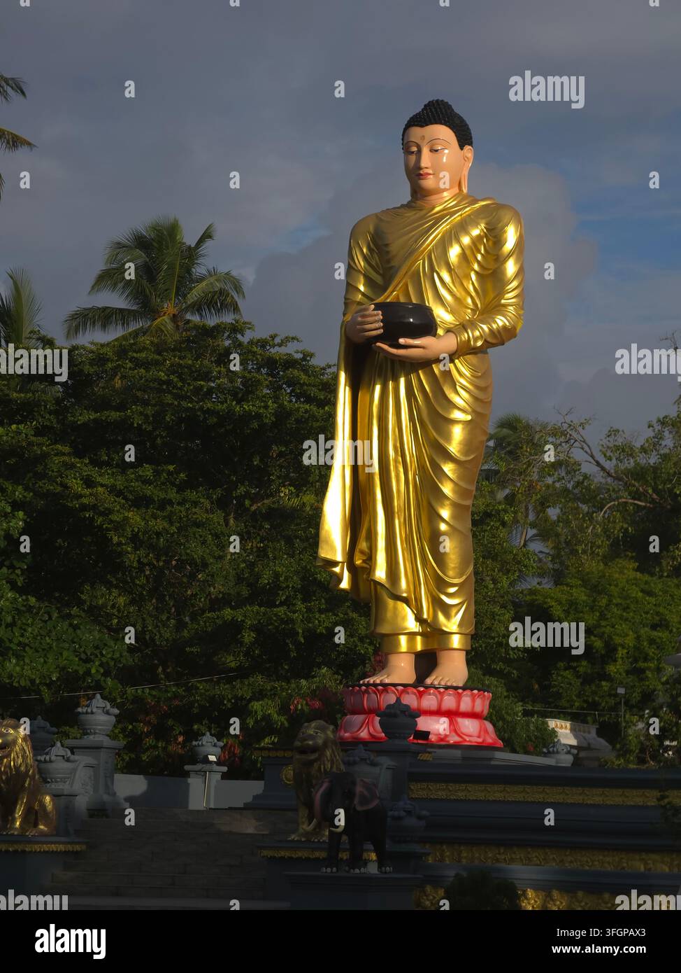 Vue verticale rapprochée d'une magnifique statue de bouddha doré debout irradiant une énergie spirituelle paisible Banque D'Images