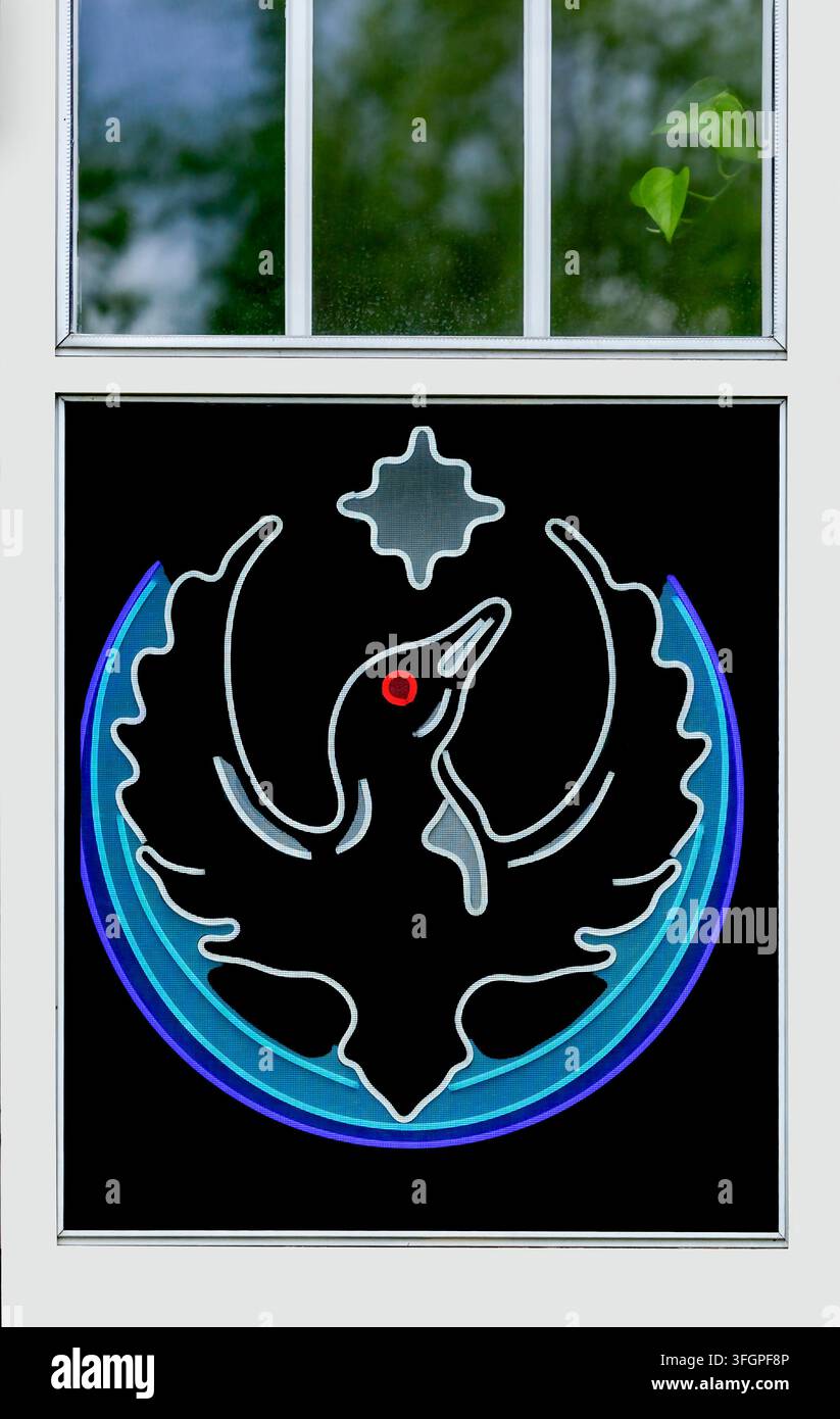 Un panneau néon électrique Rebel Loon de 2026 derrière une fenêtre grillagée à Minneapolis, Minnesota. Le symbole représente l'action collective, l'espoir et la résilience locale Banque D'Images