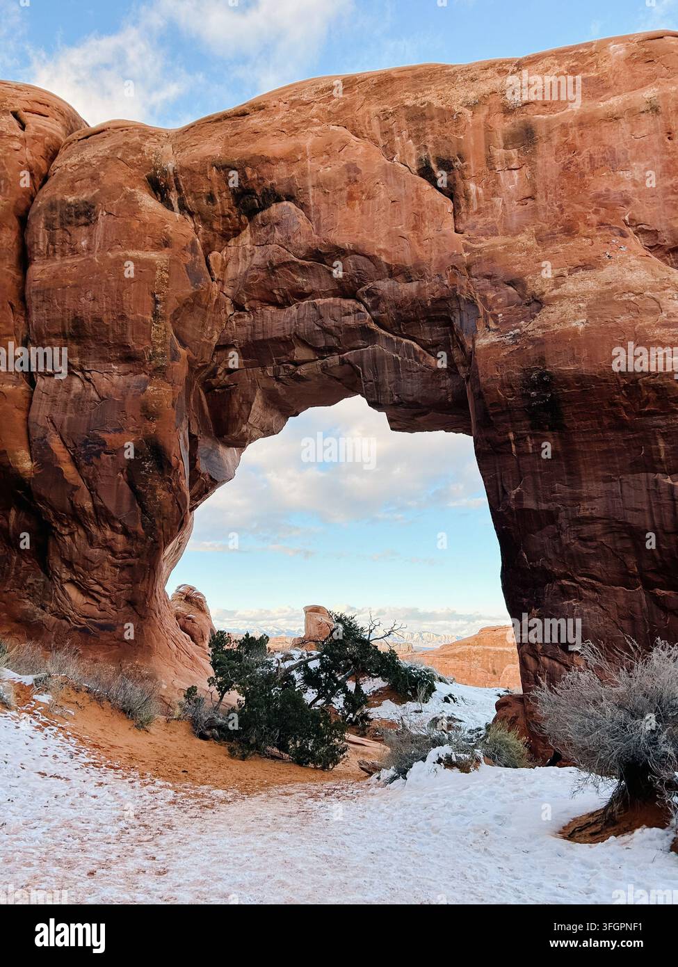 Grand arc de grès sur un chemin enneigé dans le parc national des Arches Banque D'Images