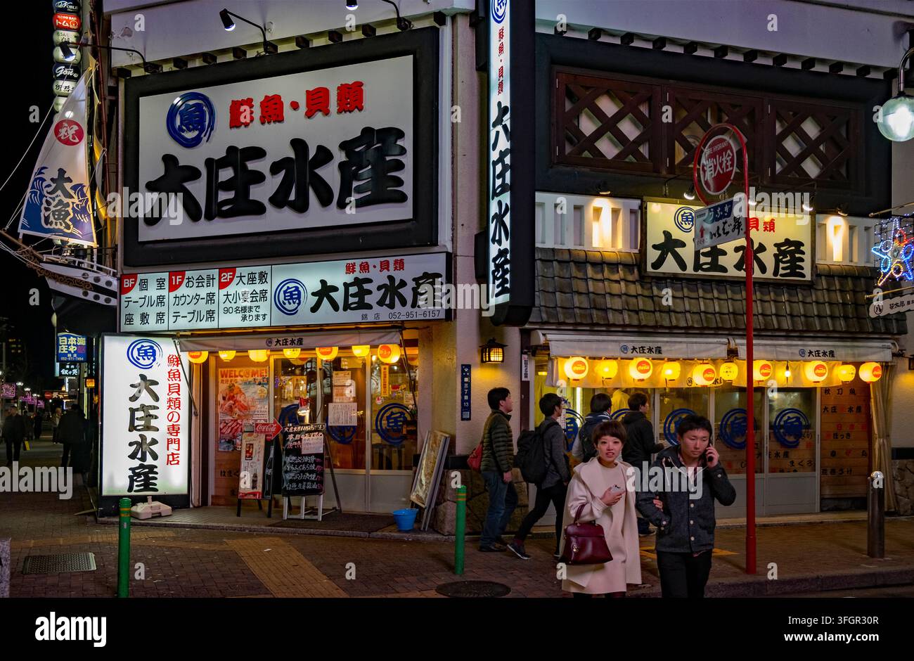 Restaurant de fruits de mer japonais Osho Fisheries à l'angle de la rue la nuit dans le quartier de divertissement Nishiki de Nagoya (名古屋), préfecture d'Aichi, Japon. Banque D'Images