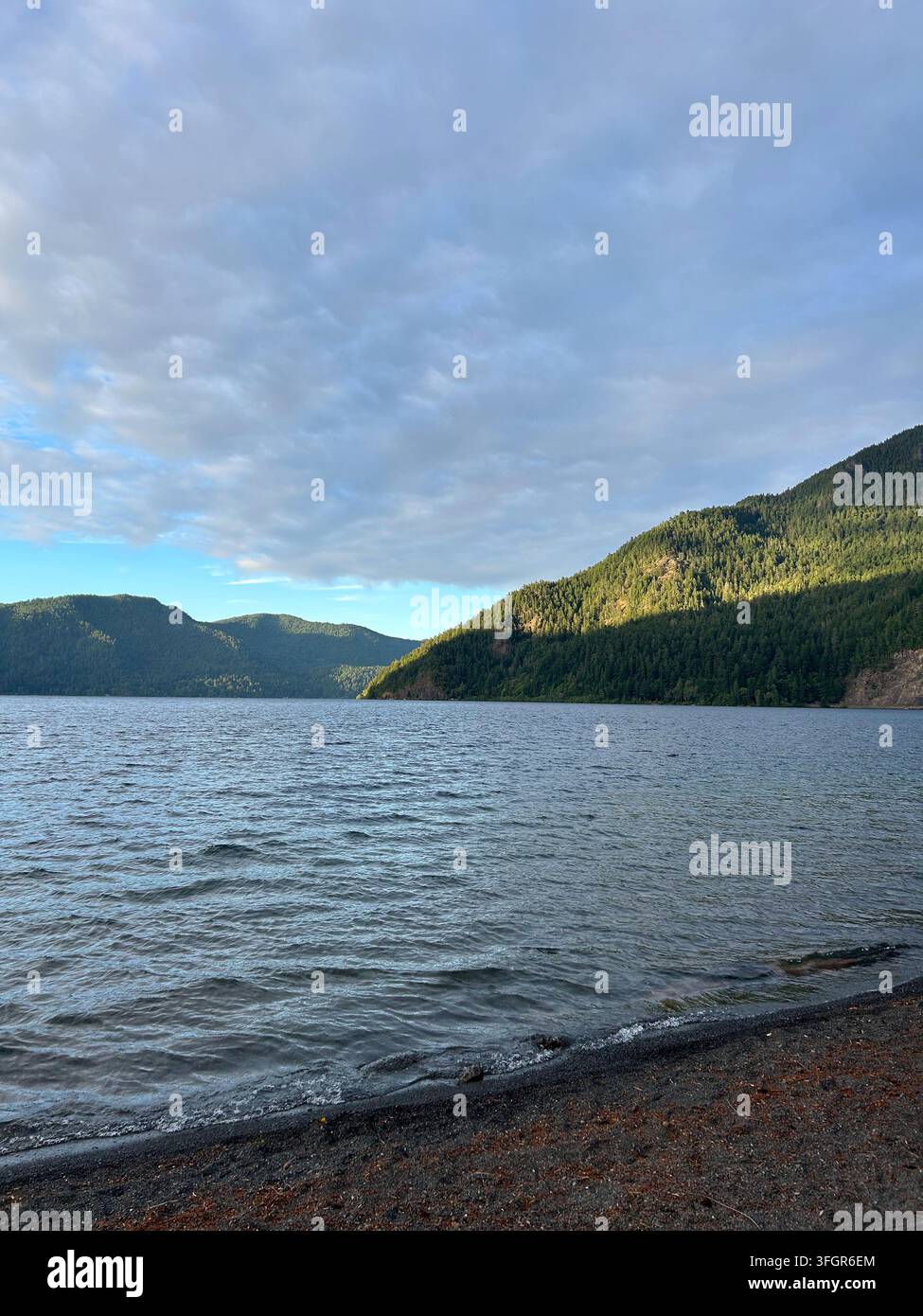 Montagnes ensoleillées et nuages au-dessus du lac Crescent, Washington Banque D'Images