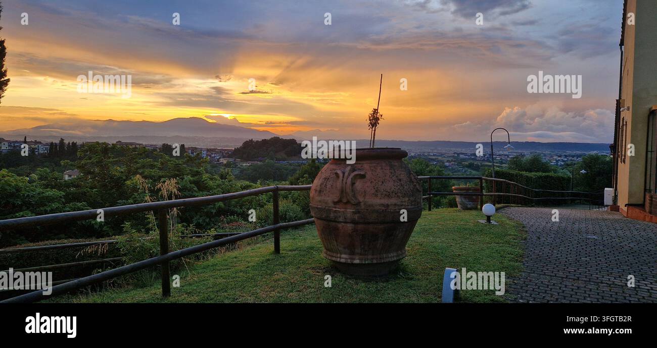 Urne en terre cuite traditionnelle sur une terrasse en colline surplombant la vallée toscane à un coucher de soleil dramatique à Montopoli in Val d'Arno. Coucher de soleil doré sur la Toscane. Banque D'Images