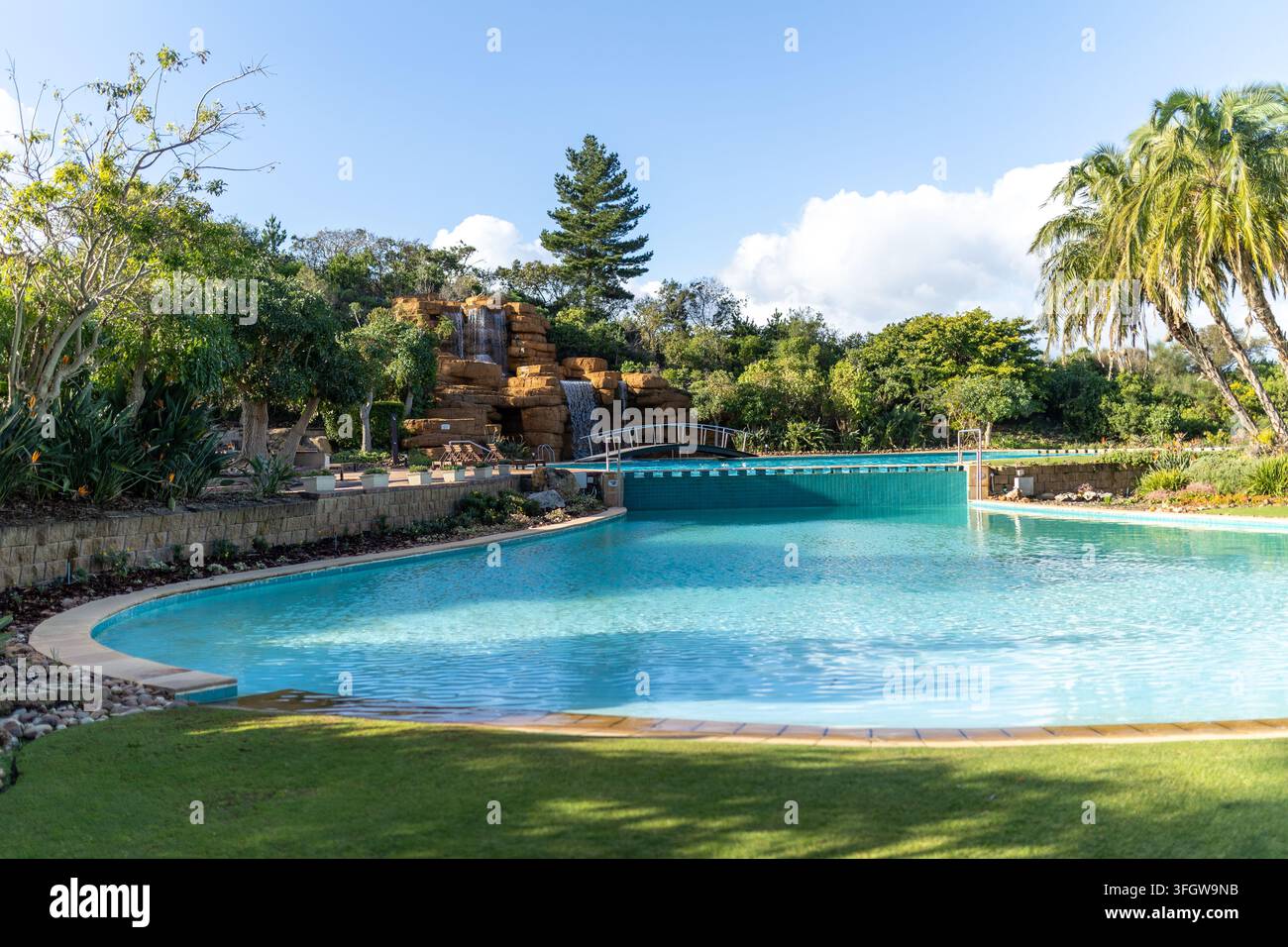 Piscine de resort avec cascade artificielle en roche et pont Banque D'Images