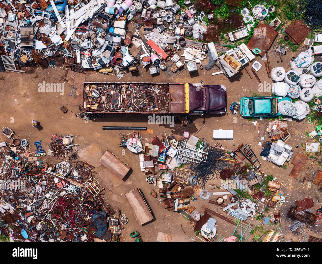Vue aérienne d'un centre de recyclage métallique avec un gros camion chargé de ferraille, des piles de matériaux jetés et des déchets industriels à Tuxpan, Jali Banque D'Images