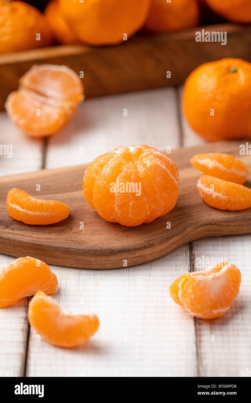 Oranges mandarine pelées sur une planche en bois Banque D'Images