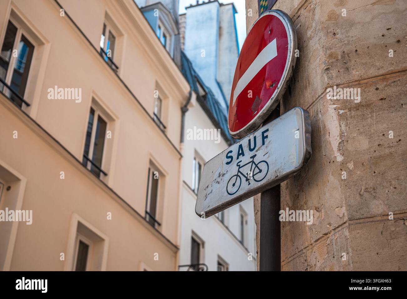 Panneau de rue de Paris affichant „sens interdit“ (accès interdit) avec le message „sauf vélo“ (sauf vélo), encourageant les transports écologiques Banque D'Images