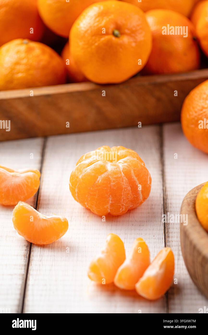 Oranges mandarine pelées sur une planche en bois Banque D'Images