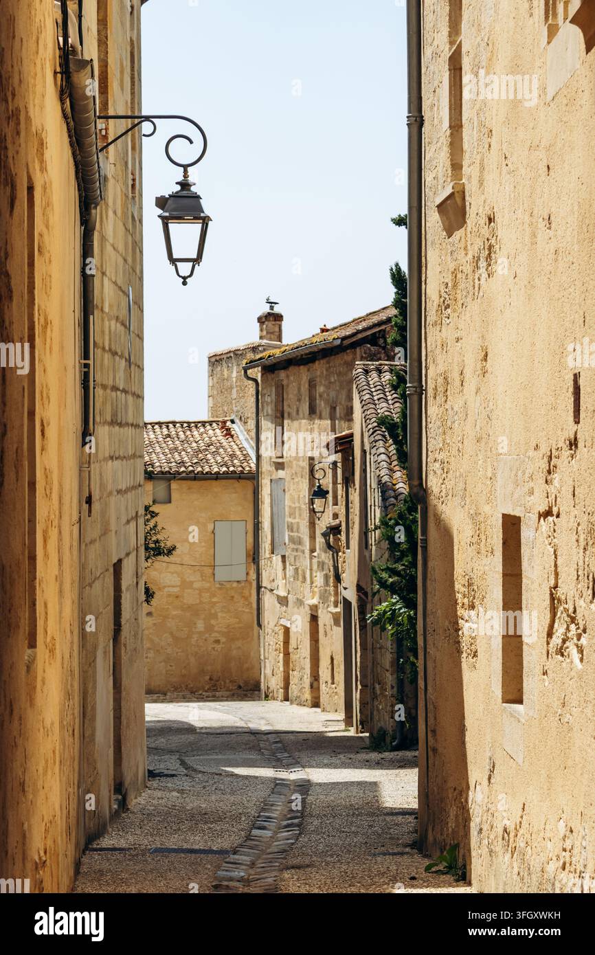 Rue historique étroite à Saint Emilion bordée de bâtiments en calcaire et de lanternes traditionnelles Banque D'Images