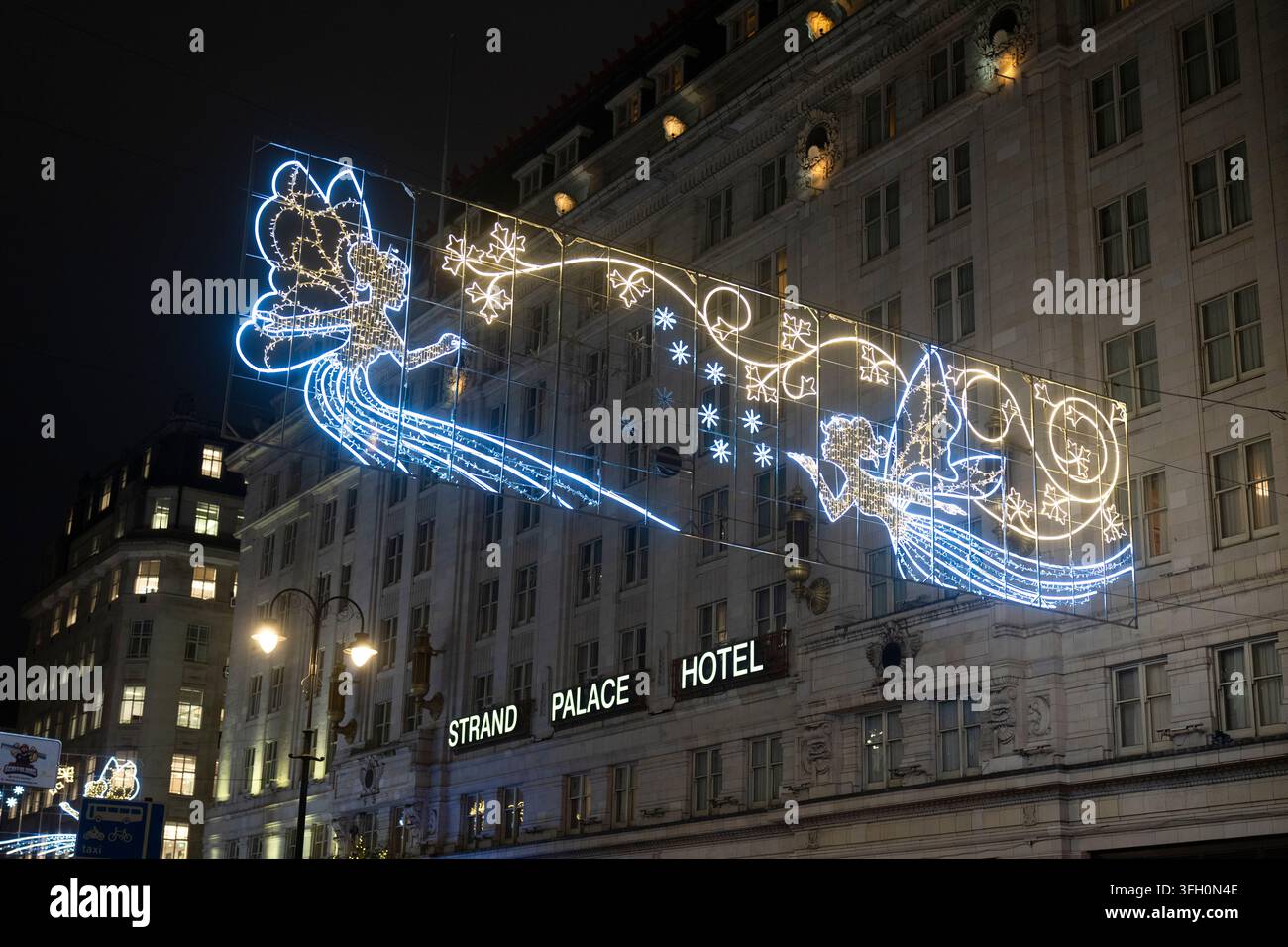 Les lumières de Noël devant le Strand Palace Hotel sur The Strand, Londres, rendent hommage à l'histoire festive du Savoy Theatre voisin. Banque D'Images