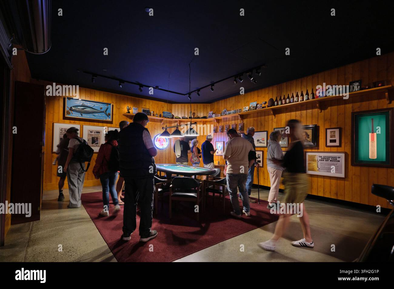 Des personnes dans une installation qui est la récréation d'une salle de loisirs de sous-sol avec une table de cartes et une table de poker. Au MONA, Museum of Old and New près de Hobart, en Australie. Banque D'Images