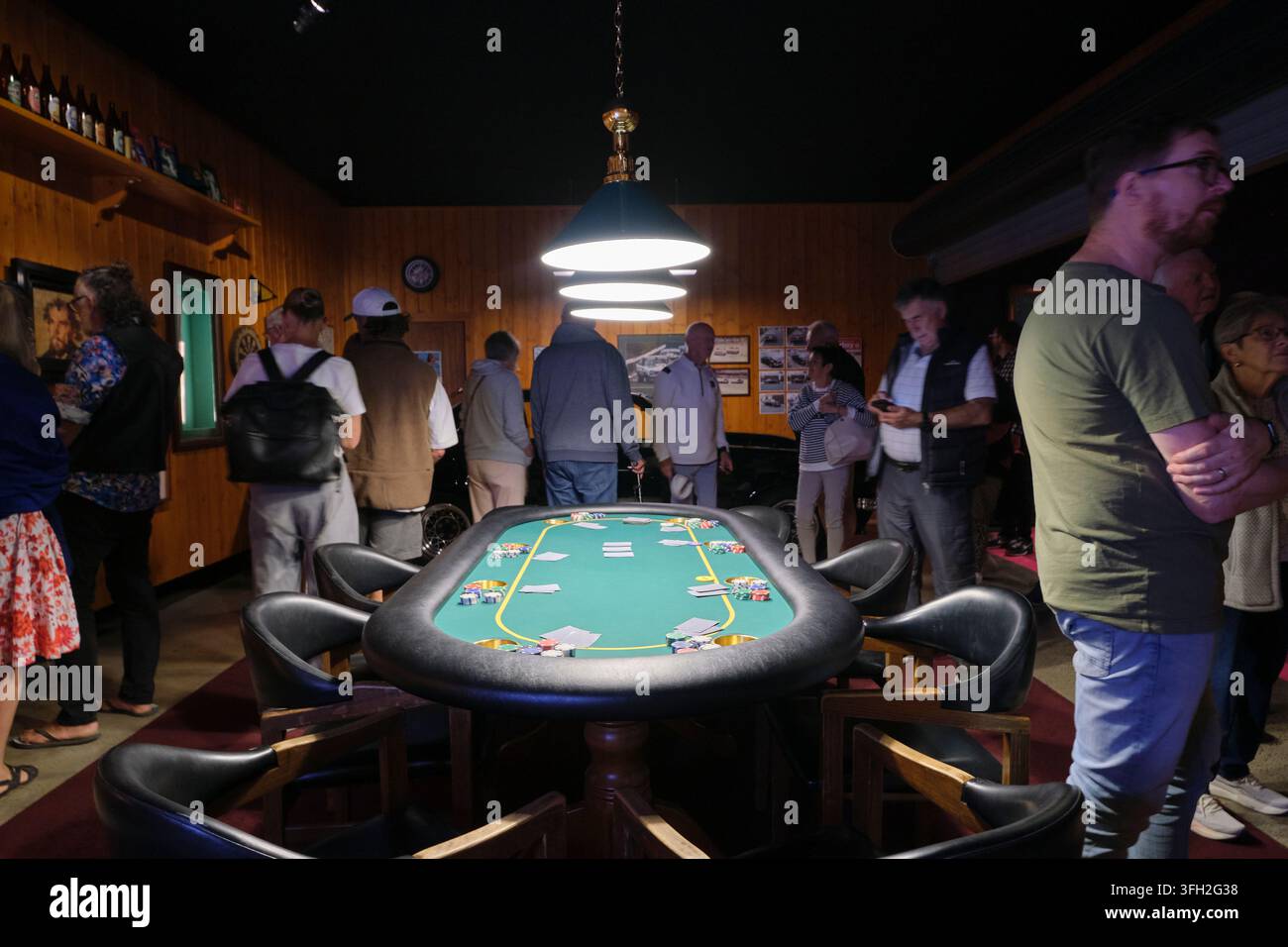 Des personnes dans une installation qui est la récréation d'une salle de loisirs de sous-sol avec une table de cartes et une table de poker. Au MONA, Museum of Old and New près de Hobart, en Australie. Banque D'Images