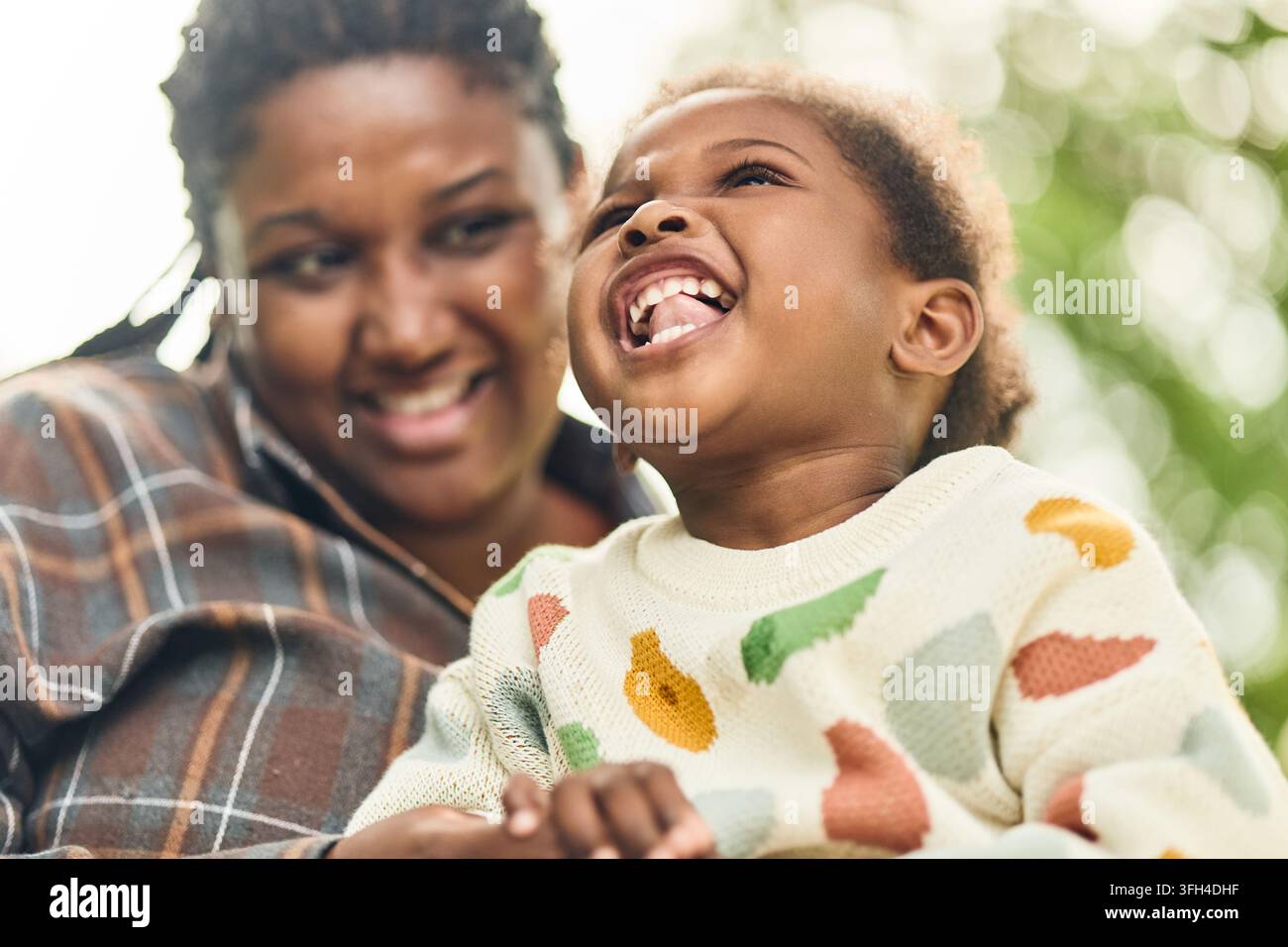Mère et fille noires heureuses riant ensemble en plein air Banque D'Images