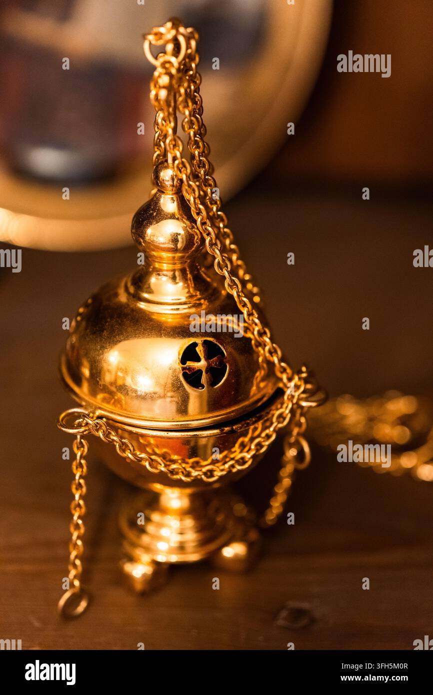 Encensoir chrétien doré orné de chaînes et d'une ouverture en forme de croix utilisé pour brûler de l'encens pendant la liturgie de l'église Banque D'Images