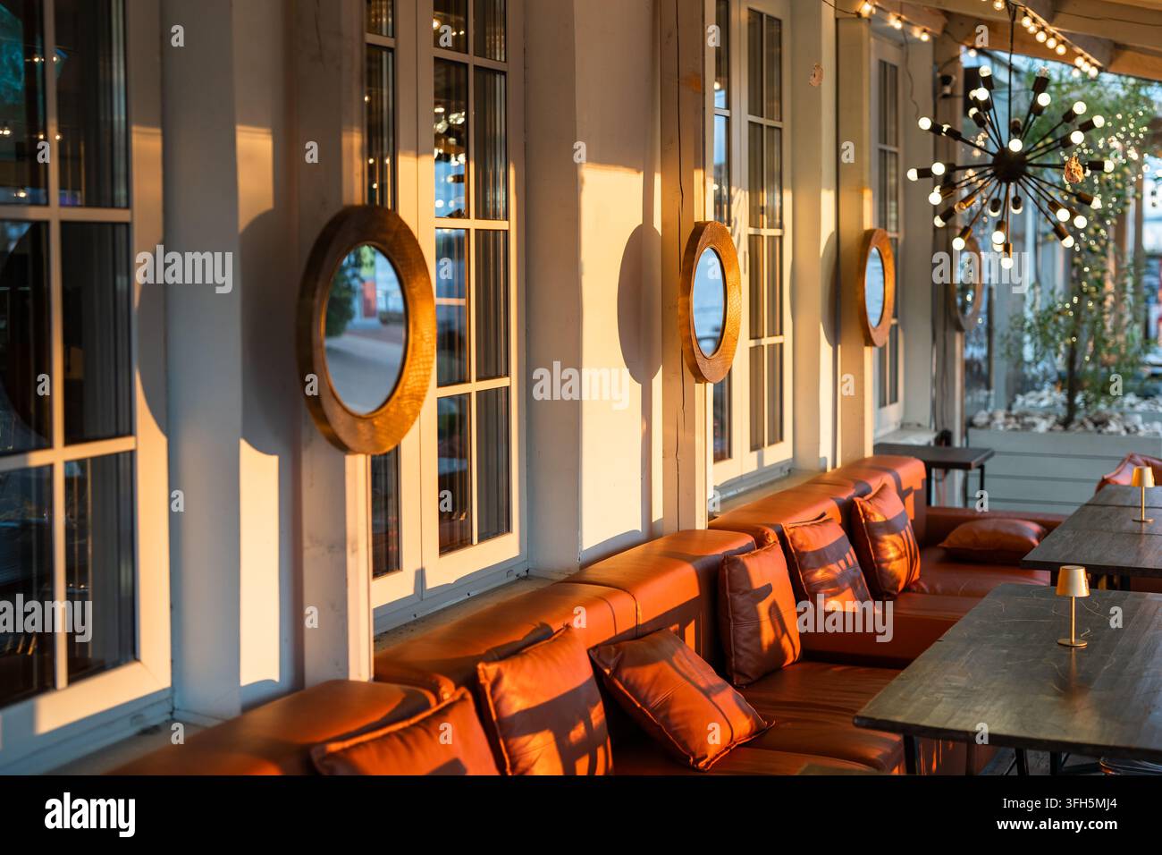 Intérieur de la terrasse extérieure du restaurant avec des canapés confortables et des tables pour observer le coucher du soleil. Banque D'Images