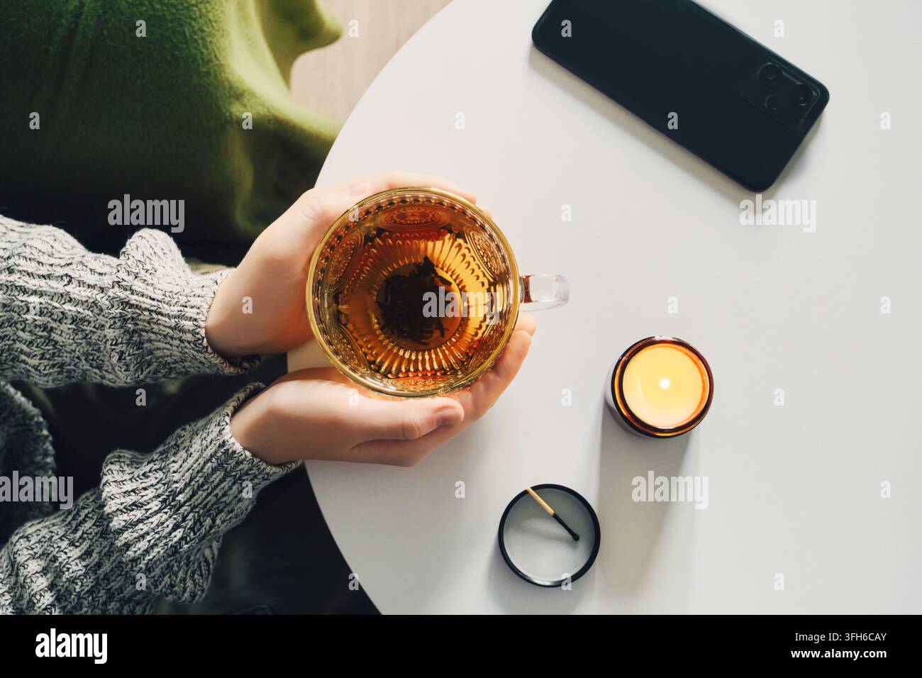 Rituel du soir tranquille avec du thé et la lumière des bougies. Concept de détox numérique Banque D'Images